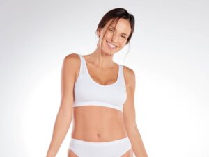 Confident woman in her early 40s has a flat tummy after abdominoplasty.